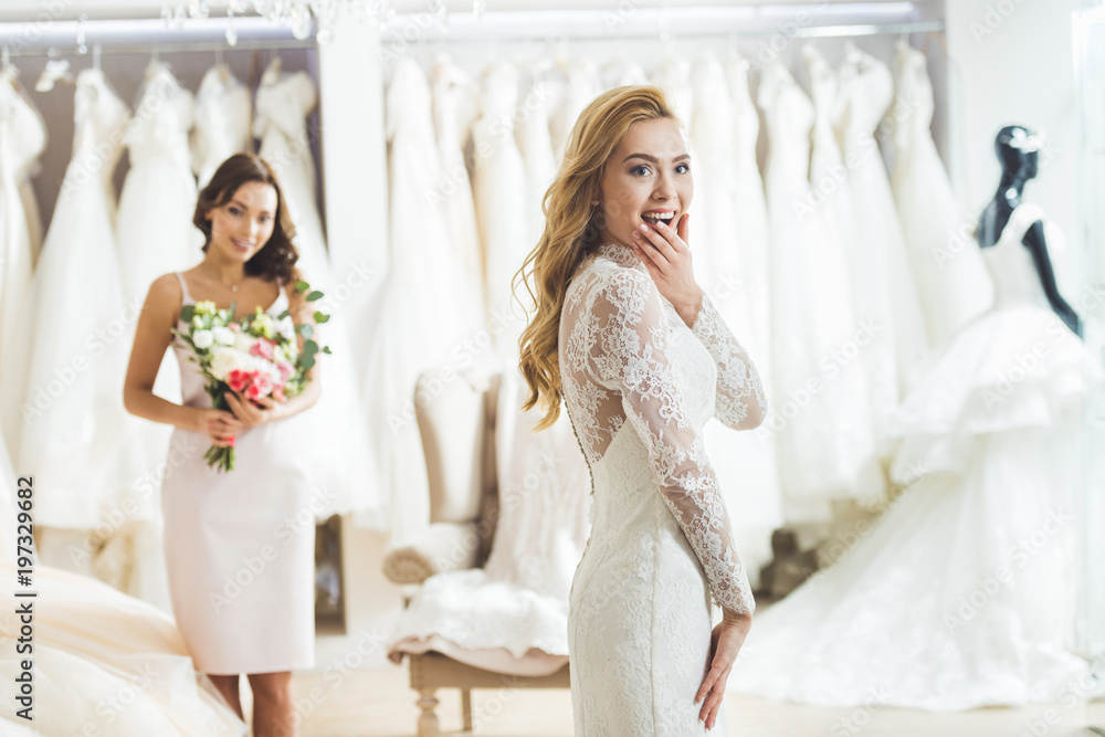 Attractive woman in wedding dresses and bridesmaid in wedding atelier