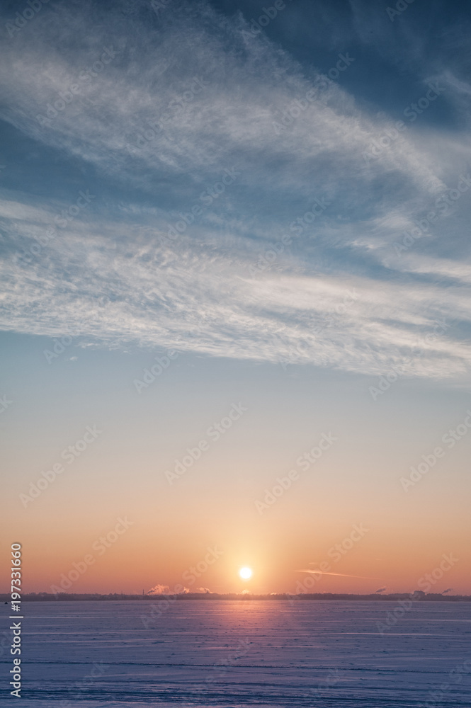 Fototapeta premium Cold winter landscape with snow, sky and sun on the horizon