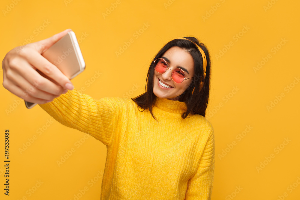 Naklejka premium Charming hipster girl taking selfie