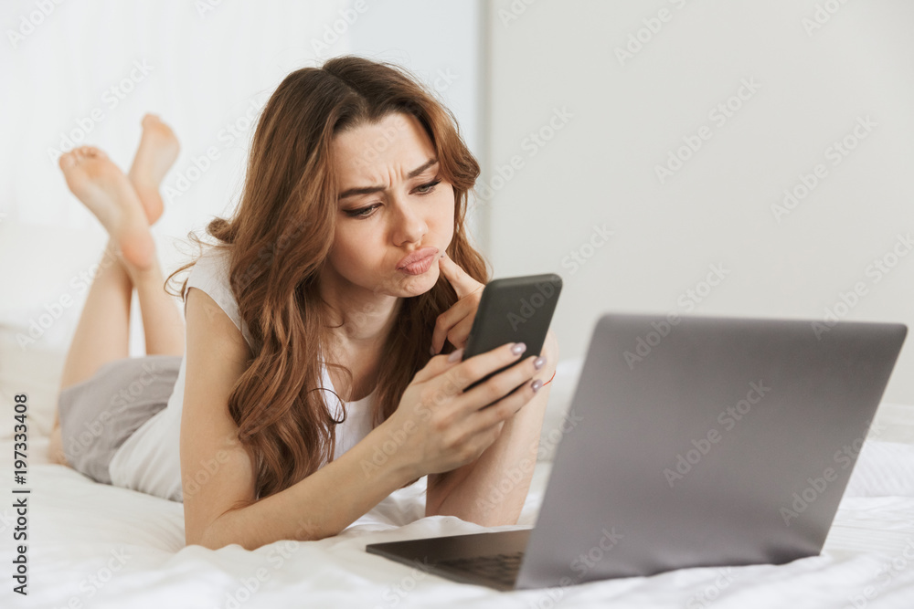 Portrait of an upset young woman holding mobile phone Portrait of an upset young woman holding mobile phone