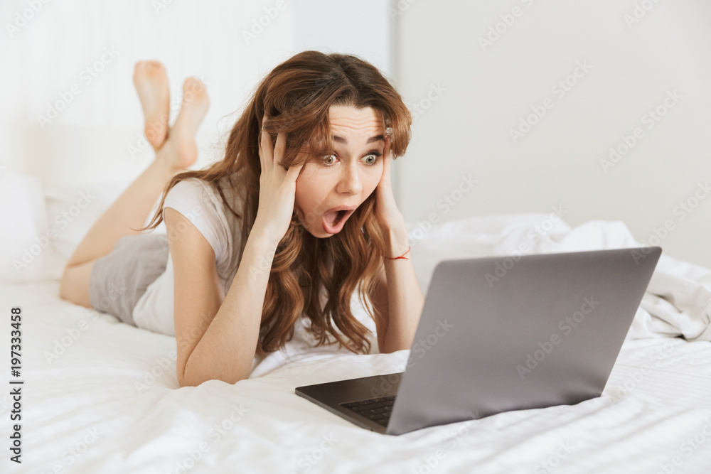 Portrait of an astonished young woman lying in bed at home Portrait of an astonished young woman lying in bed at home
