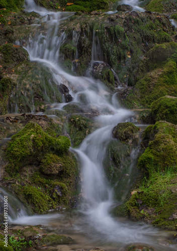 Fototapeta Naklejka Na Ścianę i Meble -  Waterfall in the forest. Green moss and stones.