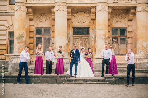 Couple of newlyweds, bride and groom together with bridesmaids and groomsmen drinking champagne outdoors hands closeup, wedding celebration with friends .  © nataliakabliuk