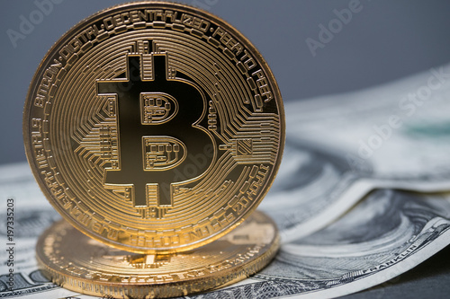 golden bitcoins on the background of 100 dollar bills photo