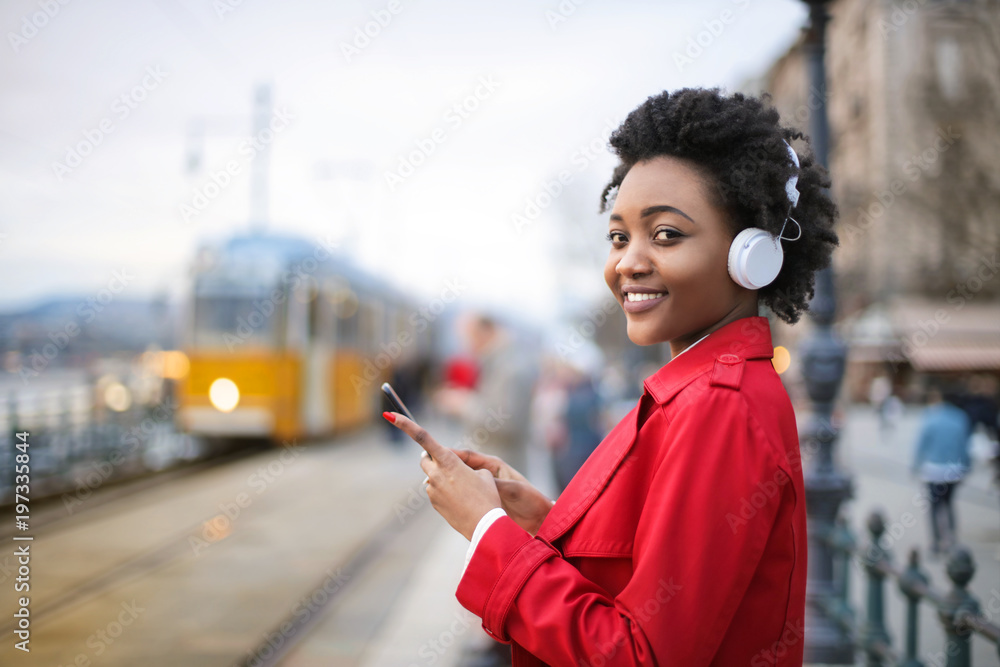 Fototapeta premium Girl listening music, while waiting for the train