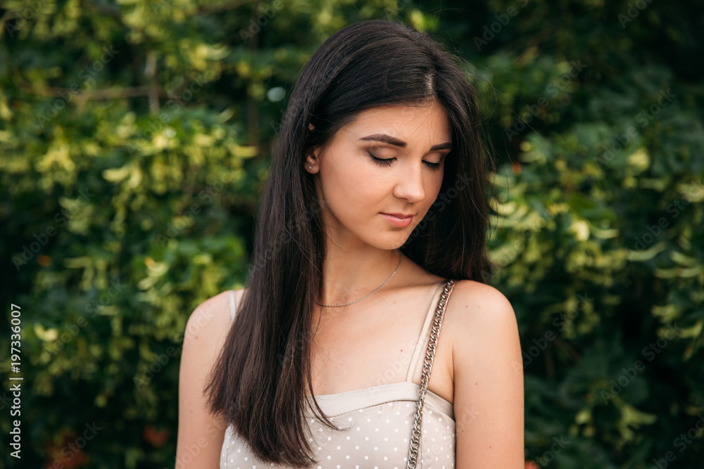 Brunette girl with makeup is standing in front of green background Brunette girl with makeup is standing in front of green background