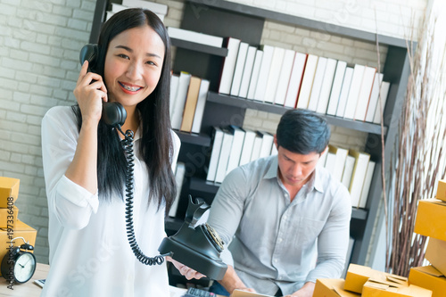 business co worker man and woman contact customer to order shopping with telephone and box package in home office, clear tone process style