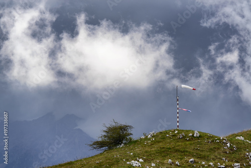 Windsock and dramatic rain clouds on the top of the mountain.