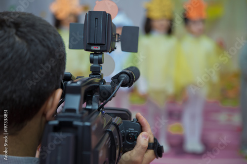 Video operator records the video on the unbranded video camera. Video camera operator working his equipment video, camera, media . Operator in kindergarden takes Novruz holiday