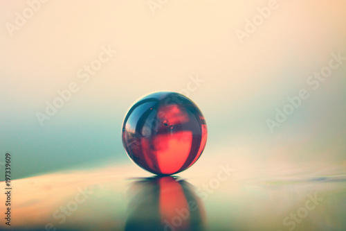 Red mable ball on a reflecting surface