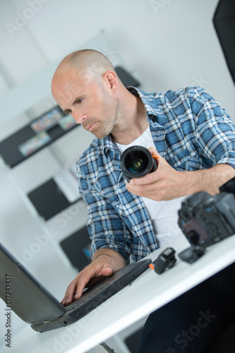 man looking at broken photographic lense
