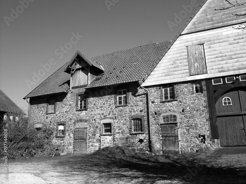 Schönes verlassenes altes Gehöft aus Bruchstein im Sonnenschein in Heidenoldendorf bei Detmold am Teutoburger Wald in Ostwestfalen-Lippe, fotografiert in neorealistischem Schwarzweiß photo