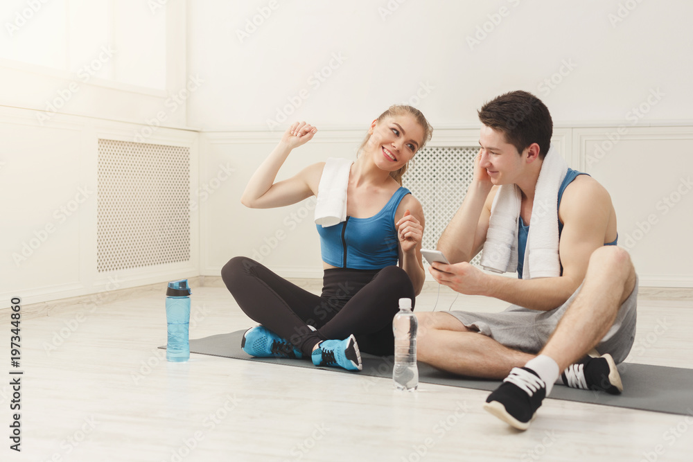 Obraz premium Fit couple with smartphone listening to music