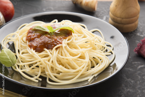 Spaghetti bolognese in black plate on vintage table background,Spaghetti with Spicy Mixed sauce and meat