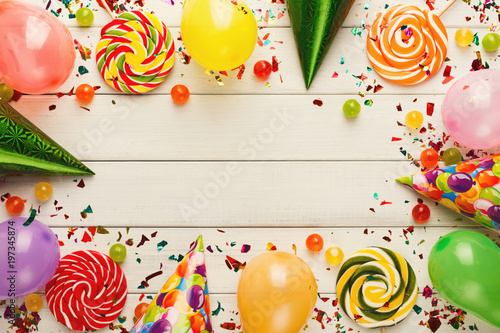 Colorful balloons on white rustic wood, birthday background, top view