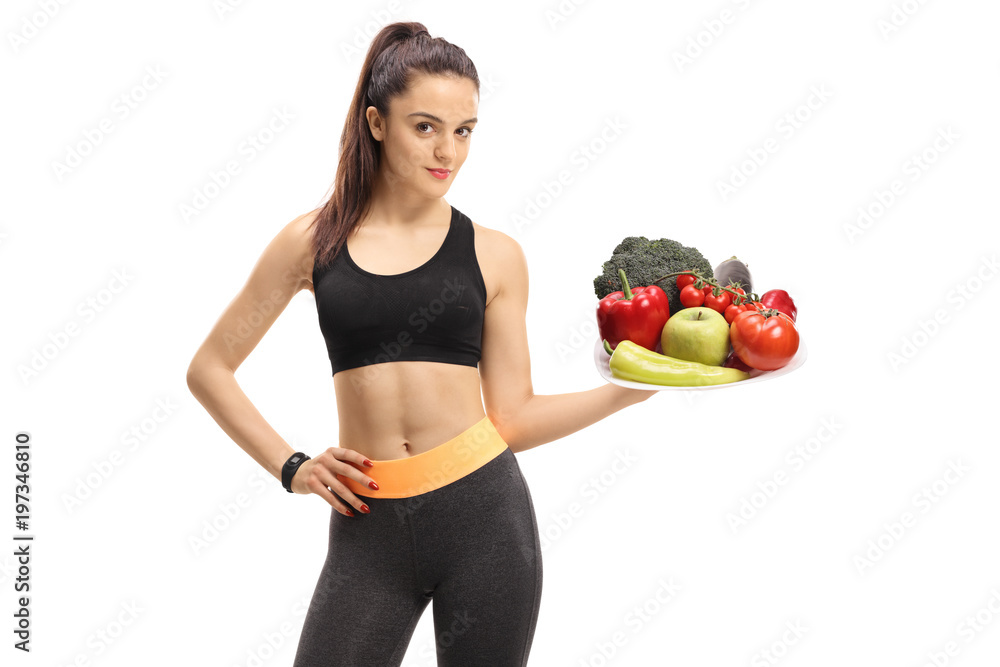 Fitness girl holding a plate of vegetables and fruit Fitness girl holding a plate of vegetables and fruit