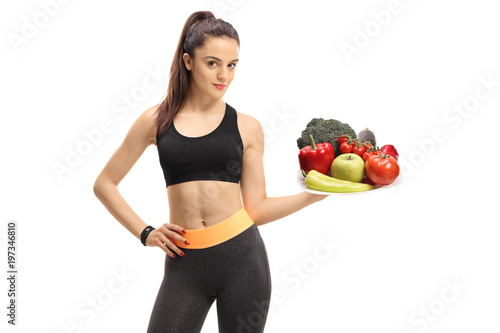Fitness girl holding a plate of vegetables and fruit © Ljupco Smokovski