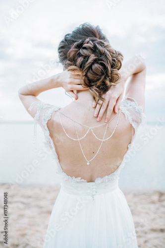 Young pretty woman in elegant dress. Back view bridal fashion background. Monochrome. photo