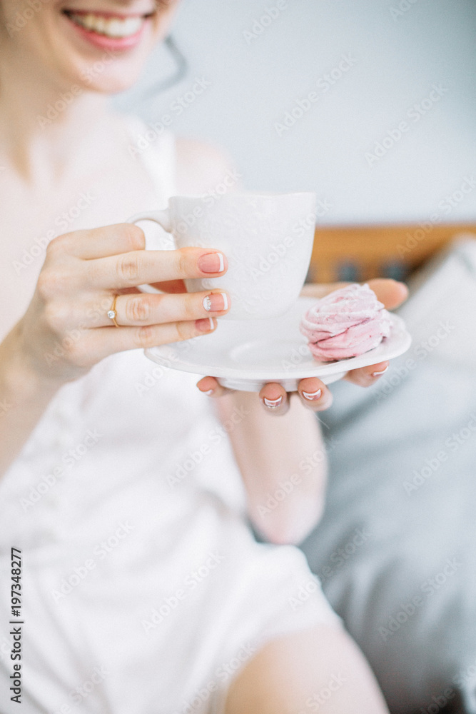 Young woman holding cup of coffee and cookie. Young woman holding cup of coffee and cookie.