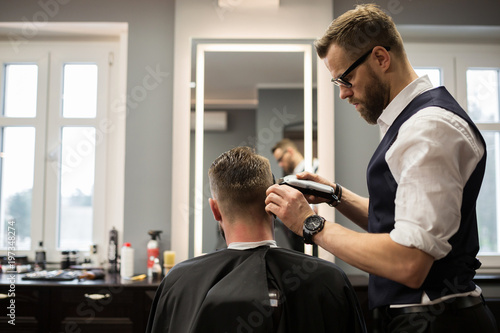 Focused barber having customer hair