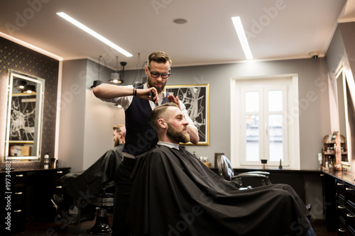 Smiling man having hair cut in salon