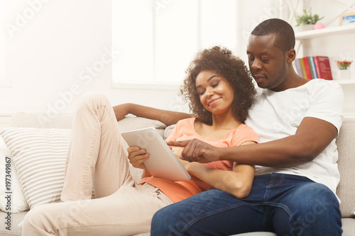 Black couple making using digital tablet at home