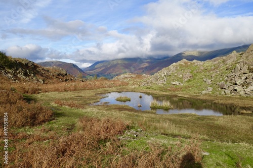 Beautiful fall landscape in Lake District, England, United Kingdom, deserted hiking trail in north of England, scenic beauty spot, peat marshlands and lakes, fall colours and blue sky in autumn photo