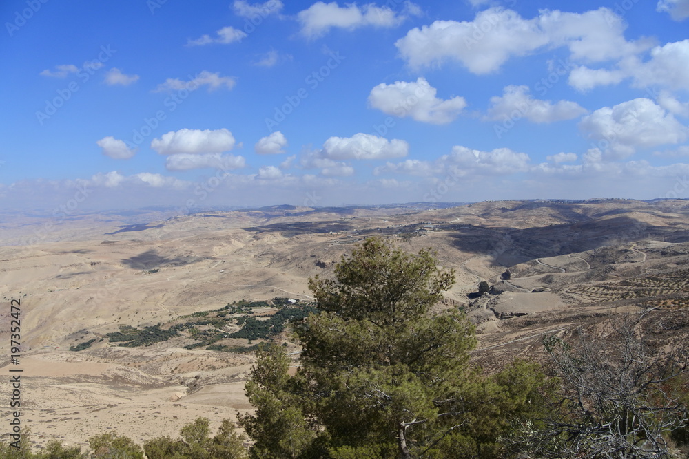 Weiße Wolken und blauer Himmel am Berg Nebo in der jordanischen Wüste 