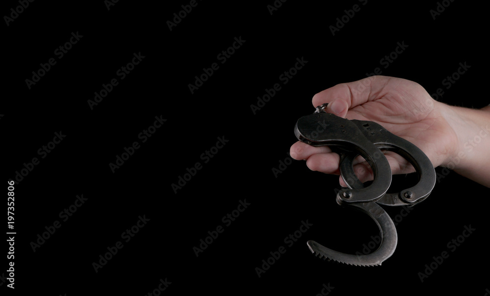 Obraz premium steel handcuffs of police special equipment, fetters on a black background