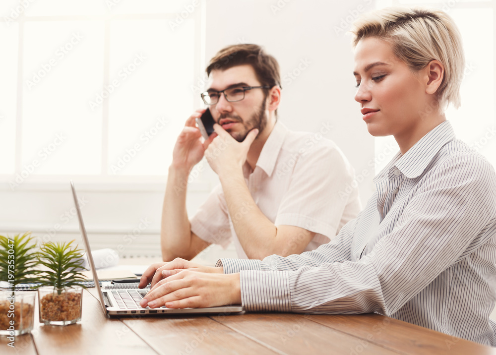 Couple of young colleagues working at modern office Couple of young colleagues working at modern office