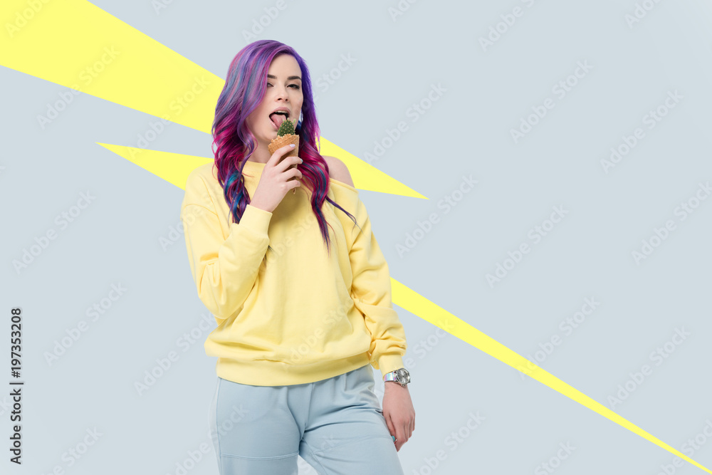 Young woman holding cactus plant in ice cream waffle cone on creative background Young woman holding cactus plant in ice cream waffle cone on creative background