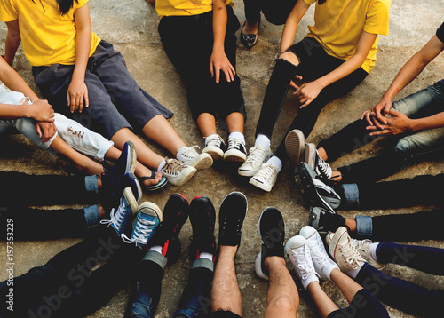 Top view image of foots of young people setinging in a circle. Concept of unity in diversity.