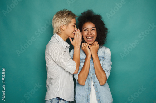 Quadro su tela Young woman telling her friend some secrets