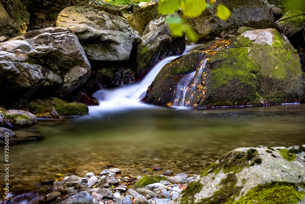 Fototapeta premium Small waterfall along a clear mountain creek in Romanian wilderness