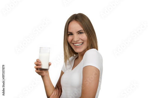 Hübsche blonde Frau hält ein Glas Milch in der Hand und lacht