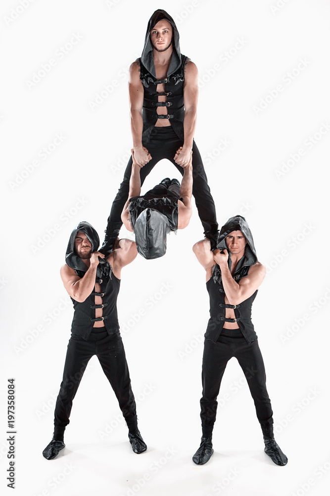 The group of gymnastic acrobatic caucasian men on balance pose The group of gymnastic acrobatic caucasian men on balance pose