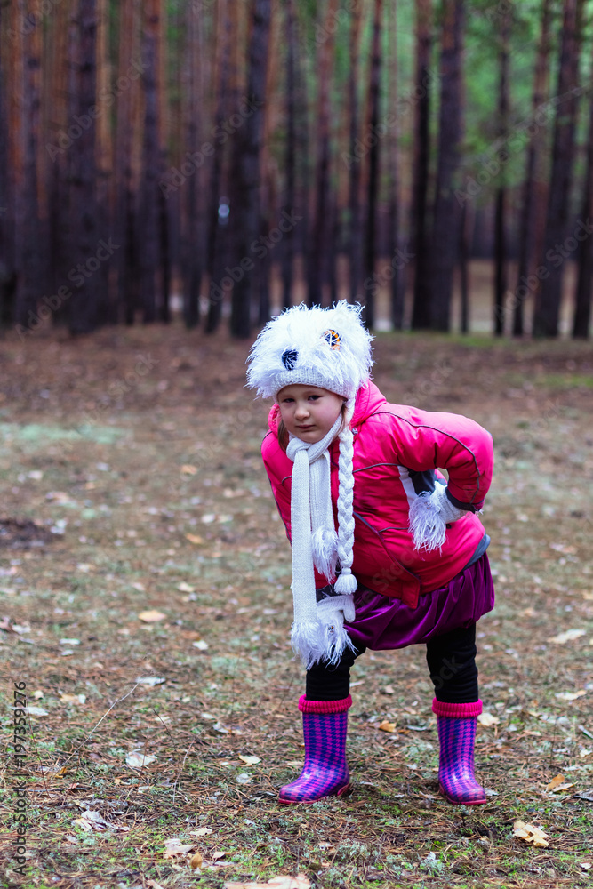 Cute little girl in pine forest in autumn time Cute little girl in pine forest in autumn time