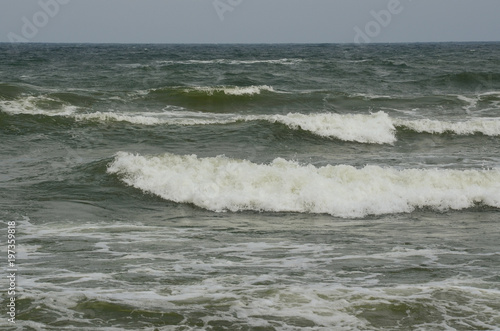 Большие штормовые волны накатываются на пляж.