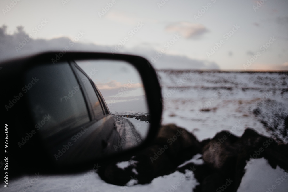 A back mirror of a car in Iceland in a snowy landscape