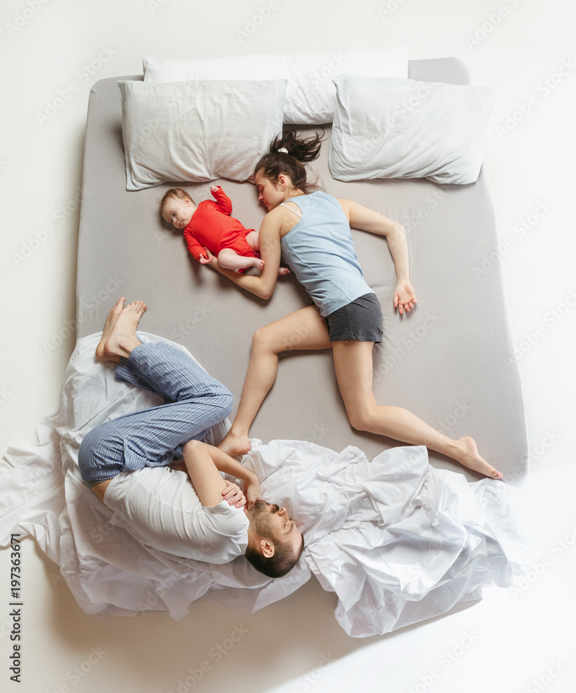 Φωτογραφία Top view of happy family with one newborn child in bedroom.