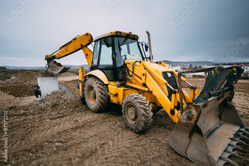 close up details of massive working machinery, industrial backhoe loader with excavator on construction site