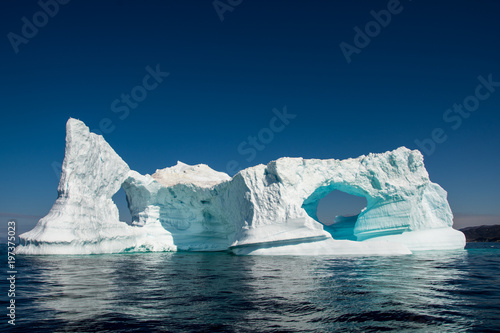 Arches in iceberg. Beautiful blue and white cristal of Nature in Greenland.