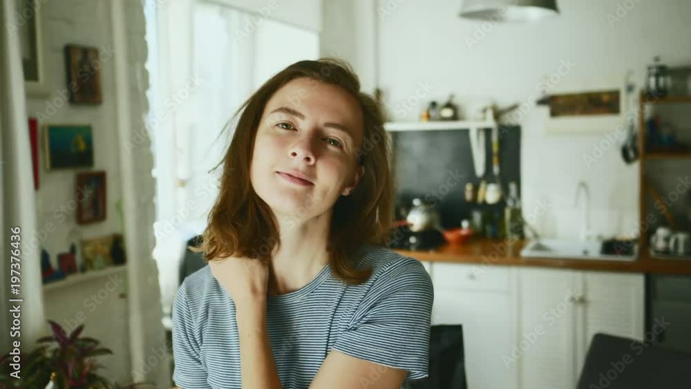 Attractive female with short blonde hair standing in kitchen smiling at camera Attractive female with short blonde hair standing in kitchen smiling at camera