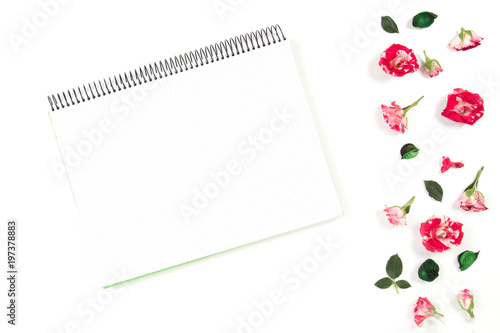 Open spiral notebook and rose frame. Flat lay, top view