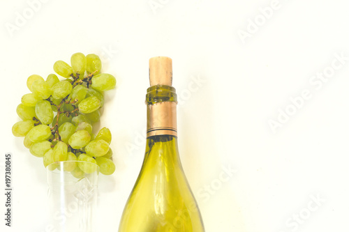 bottle of wine and a glass with a white grape brush on a white background photo