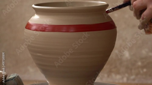 potter makes and paints a pitcher