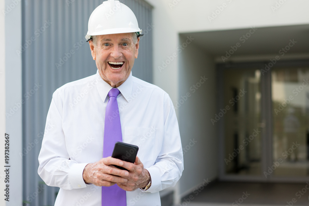 Happy Senior Building Owner Using Phone at Site Happy Senior Building Owner Using Phone at Site