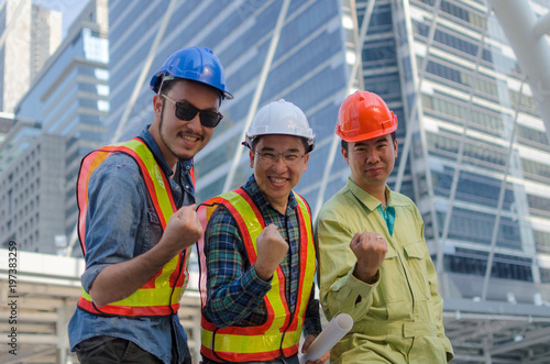 Yeah. We did it, group of engineer, technician and architect screaming showing their strong hands together standing in modern city building background, construction site and industry concept