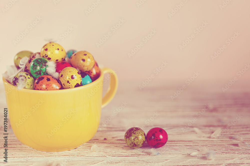 Painted colorful quail eggs in yellow bowl. Easter Spring holiday concept. Toned image Painted colorful quail eggs in yellow bowl. Easter Spring holiday concept. Toned image