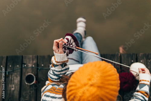 Crop woman knitting with wool